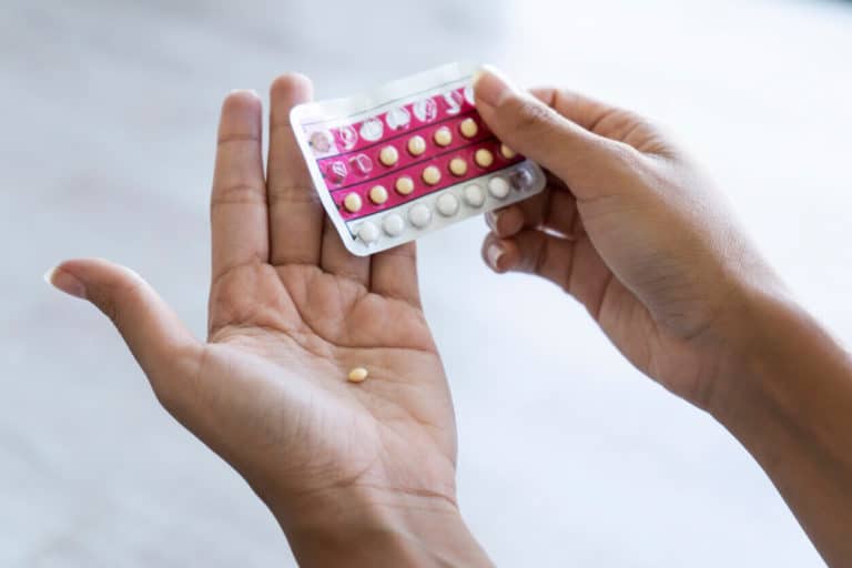 Woman holding birth control pills in her hands