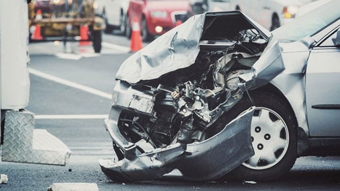 A severely damaged car, the front end is totaled after an accident.