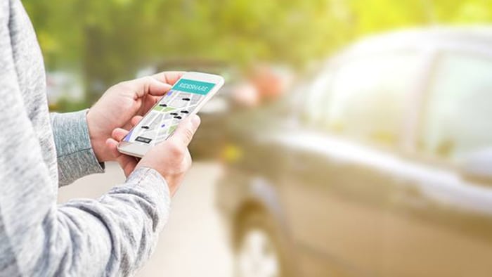 Person looking at phone ordering a ride share service