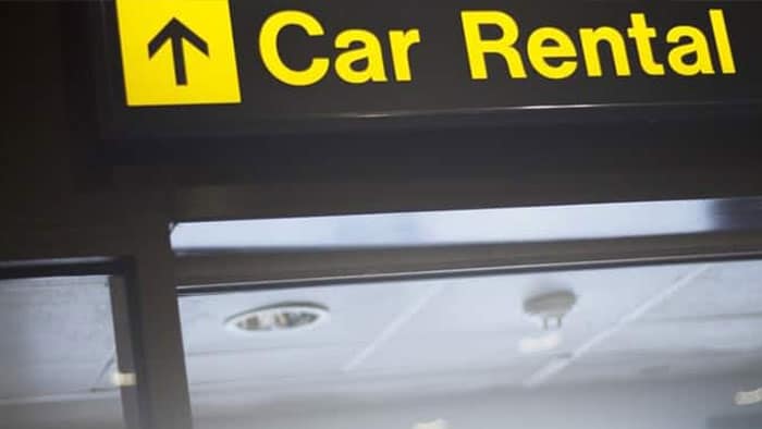 A sign showing there's a car rental with an arrow pointing straight ahead.