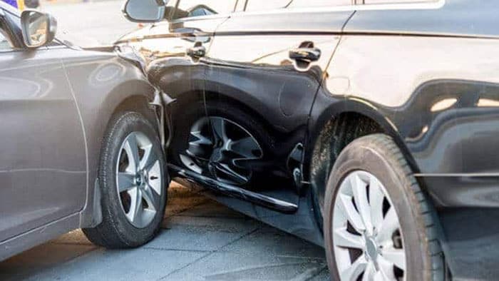 Car accident involving a gray car hitting the side of a black car