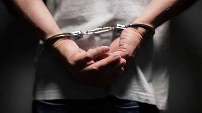 An up-close view of a person in handcuffs.