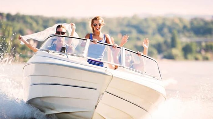 Three individuals enjoying themselves while riding on a boat.