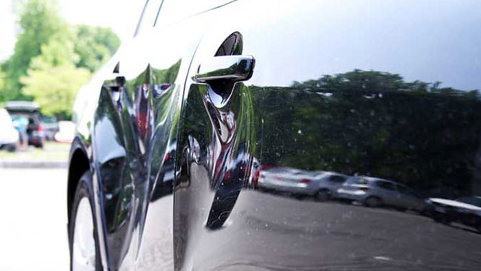 An up-close view of a dent inside a vehicle door.