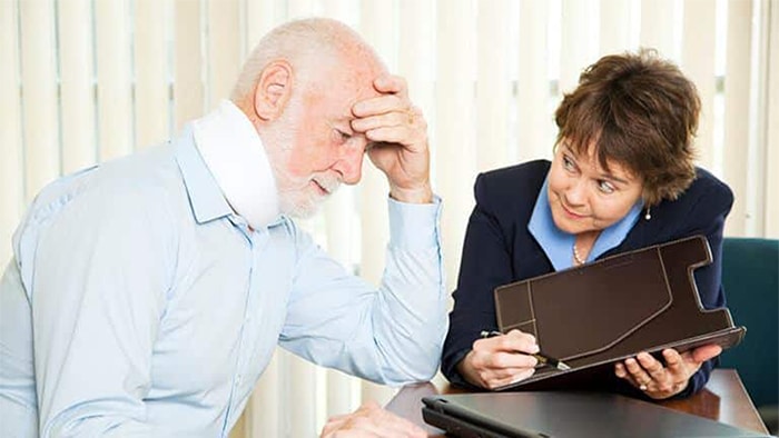 Injured elderly man meeting with personal injury lawyer