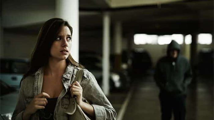 Strange person following woman in a parking garage