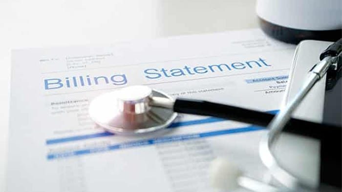 A stethoscope rests on top of a billing statement.