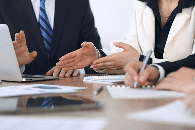 Focus is on the hands of three lawyers discussing a case.