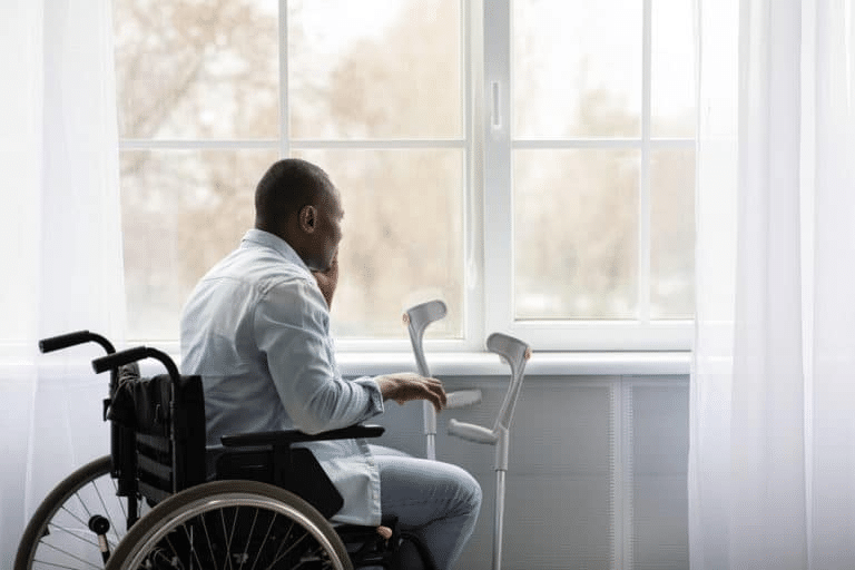 elderly man sitting in wheelchair looking out a window