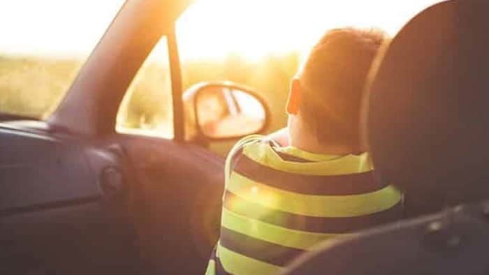 child looking out window of car