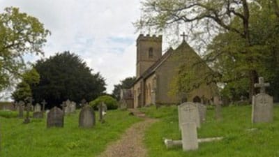 A view of a church with a graveyard in front of it.