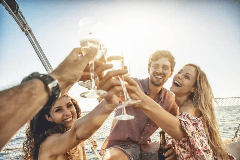 What Causes Boat Accidents? 1 Four friends are toasting their alcoholic drinks together while on a boat.