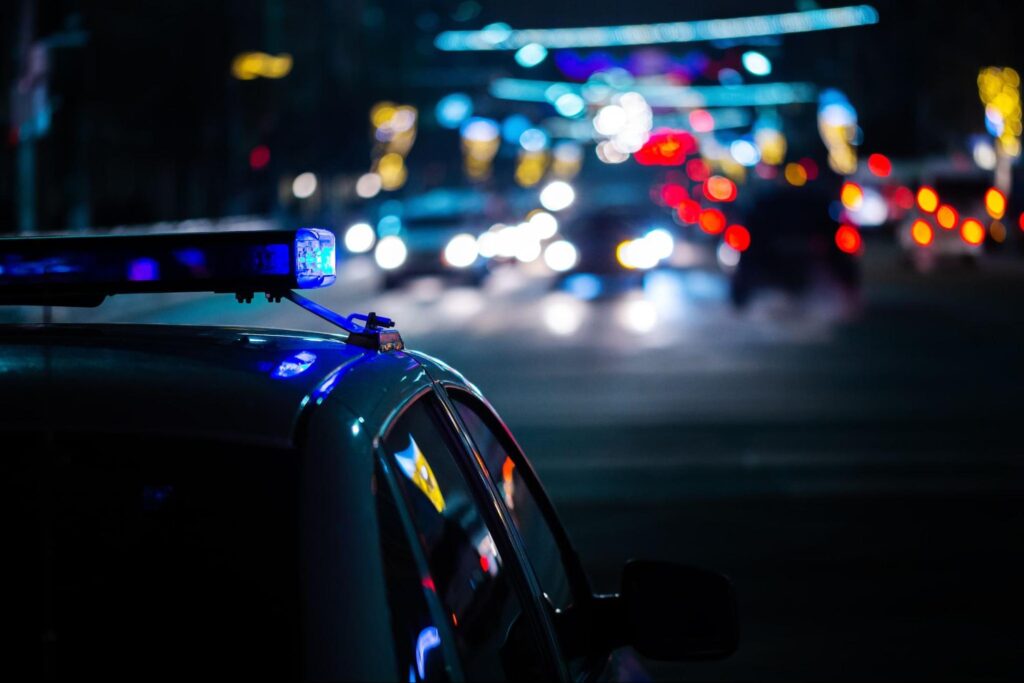 police car driving down busy road