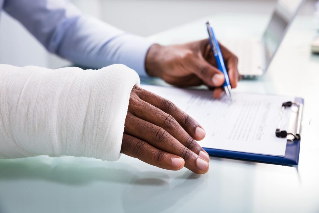 injured-arm-signing-medical-paperwork-min