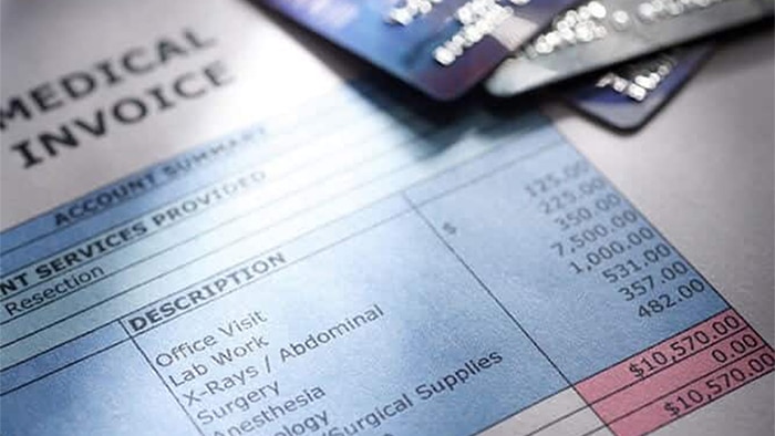 An up-close view of a medical bill and three credit cards lay in the corner, cut off from the image.