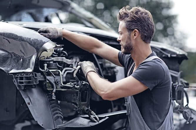 mechanic works on totaled car after accident