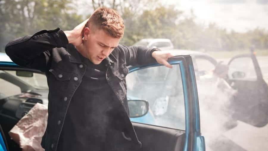 man grabing his neck after a car accident