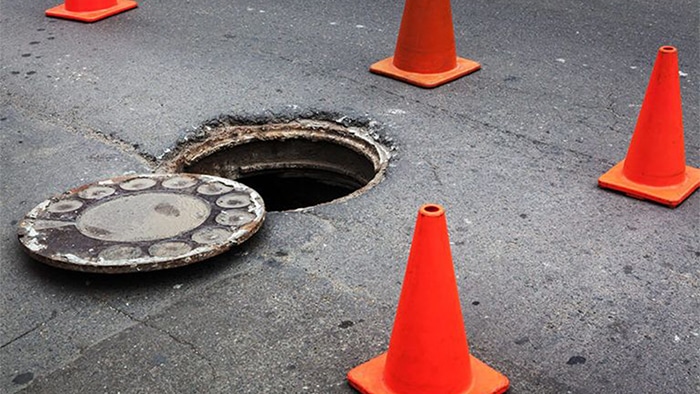 manhole cover off of sewer entry