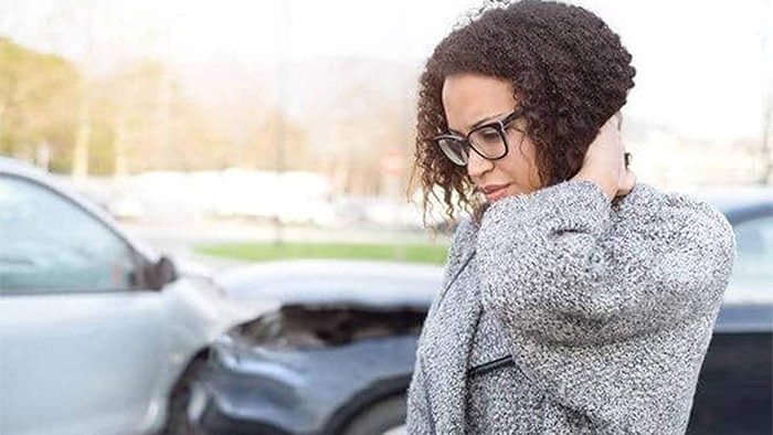 lady holding her neck after a car accident
