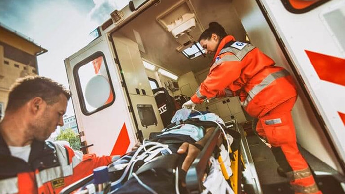 person with a catastrophic injury on a stretcher being put into an ambulance