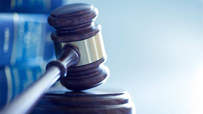 An up-close view of a gavel next to stacked books.