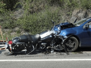 A car and motorcycle accident. Both are severely damaged.