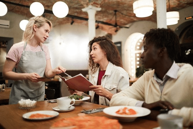 waitress taking two peoples orders at a restaurant