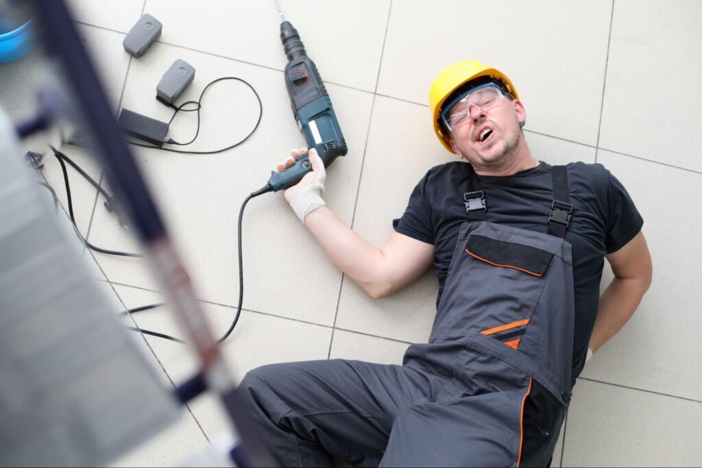 worker with drill that has had a slip and fall accident