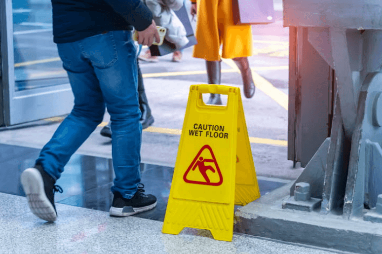 a person walking by a caution: wet floor sign