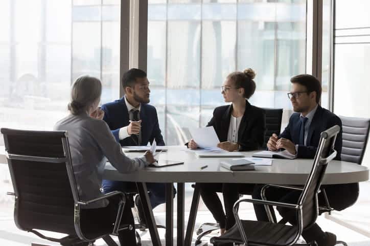 A group of lawyers surrounding a table discussing a multi-car accident.