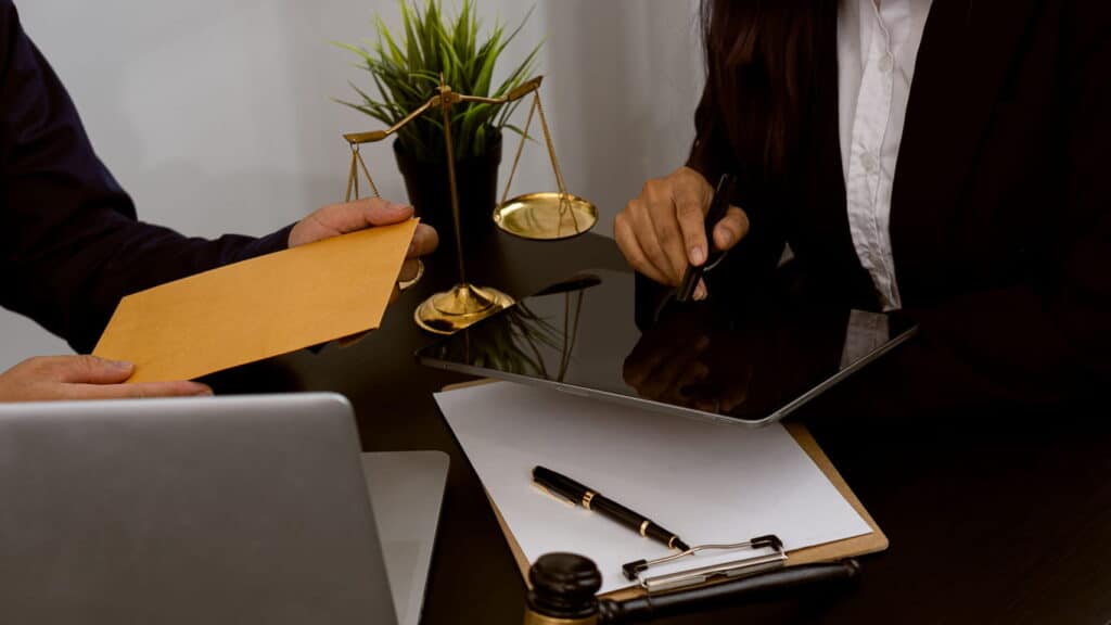 Focus is on the paperwork as two personal injury lawyers discuss a client's case.