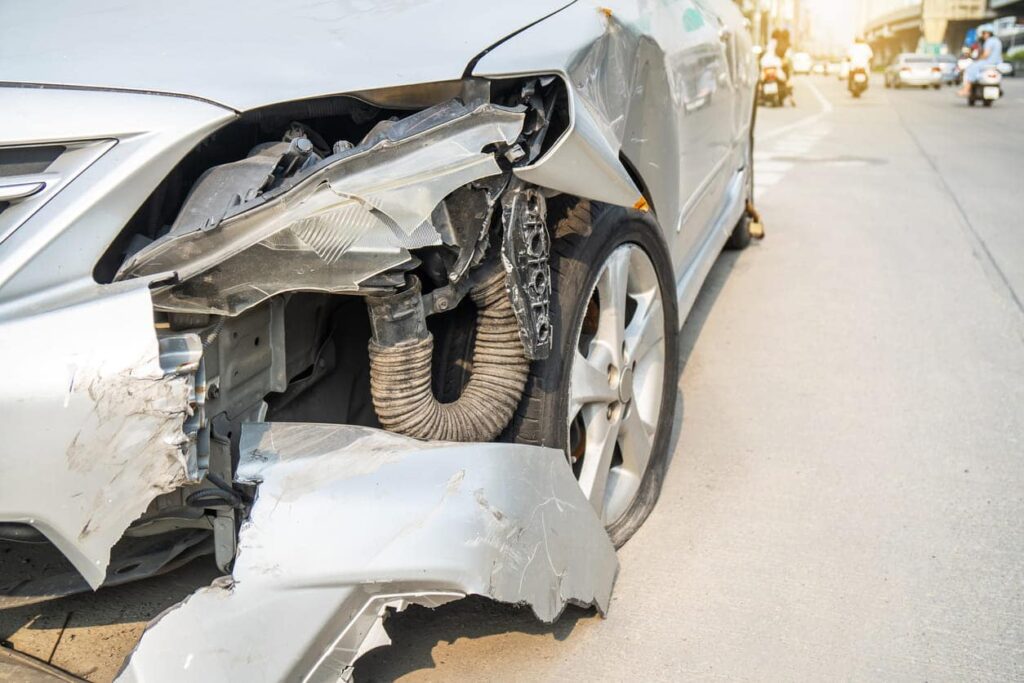 Up close view of the front-end damage to a vehicle after an auto accident.