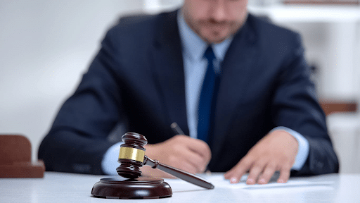 A Las Vegas auto accident attorney working at his desk on a case. There is a gavel in front of him.