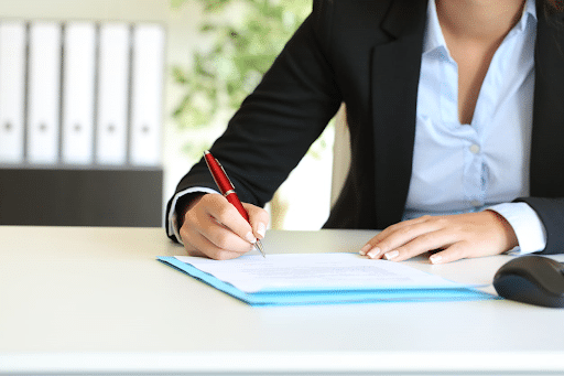 A dog bite lawyer filling out paperwork at her desk.