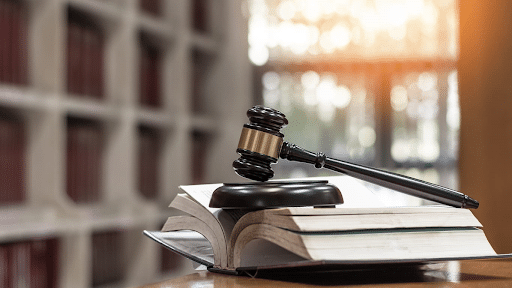 A gavel sitting on top of an open book during a civil case.