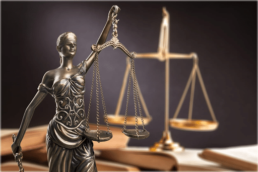 A Lady Justice statue and the scales of justice on a personal injury lawyer's desk.