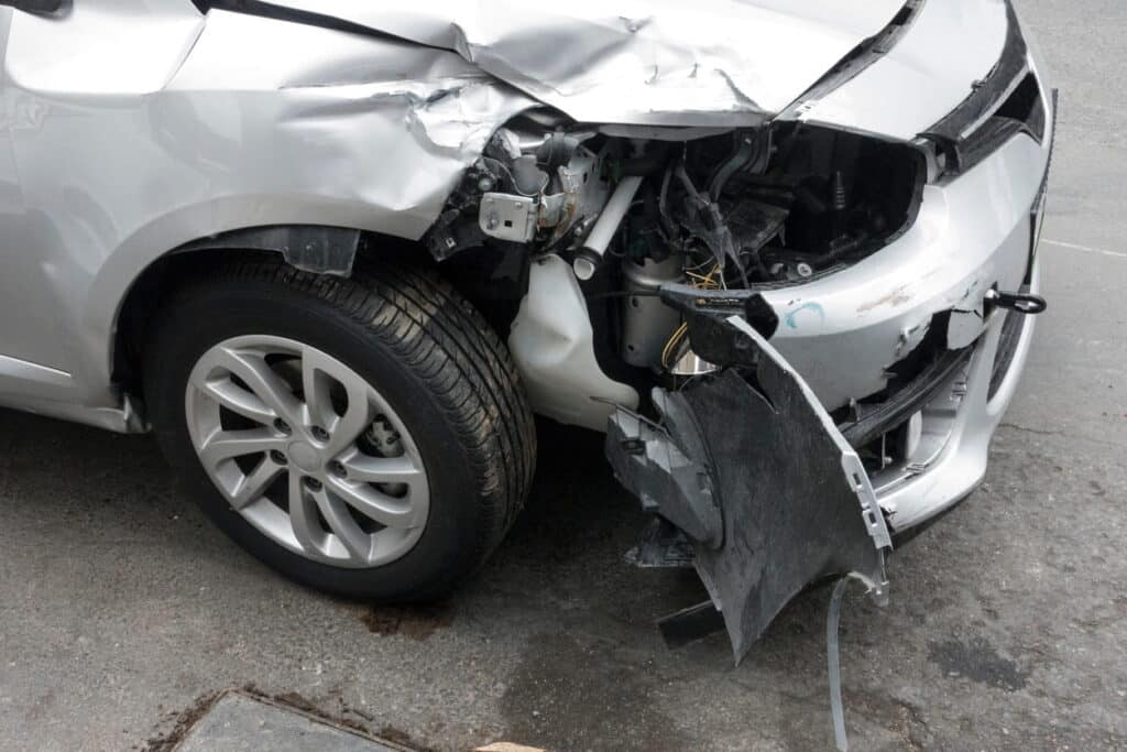 A damaged front end of a vehicle after being in a car accident in paradise.