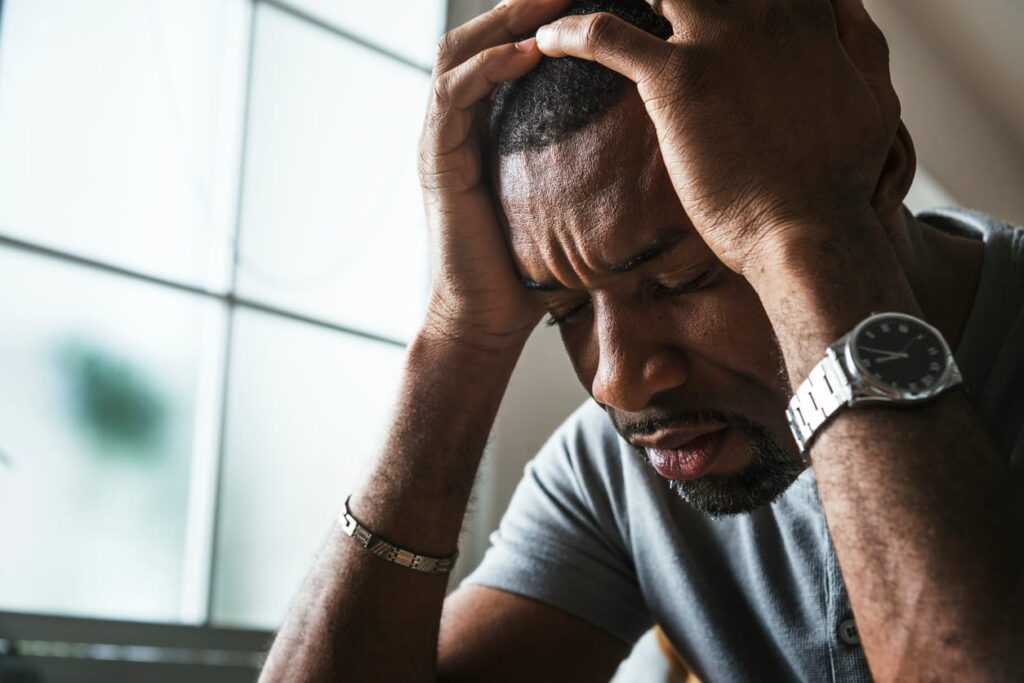 A man holding his head in emotional distress.