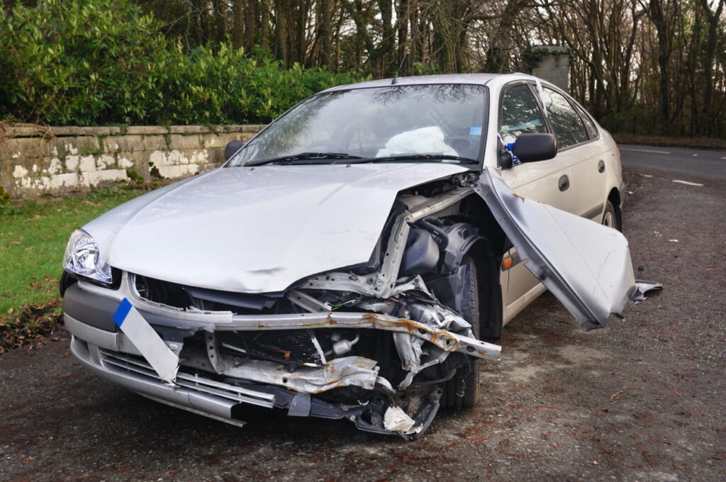A severely damaged front end of a vehicle after being in a car accident in paradise.