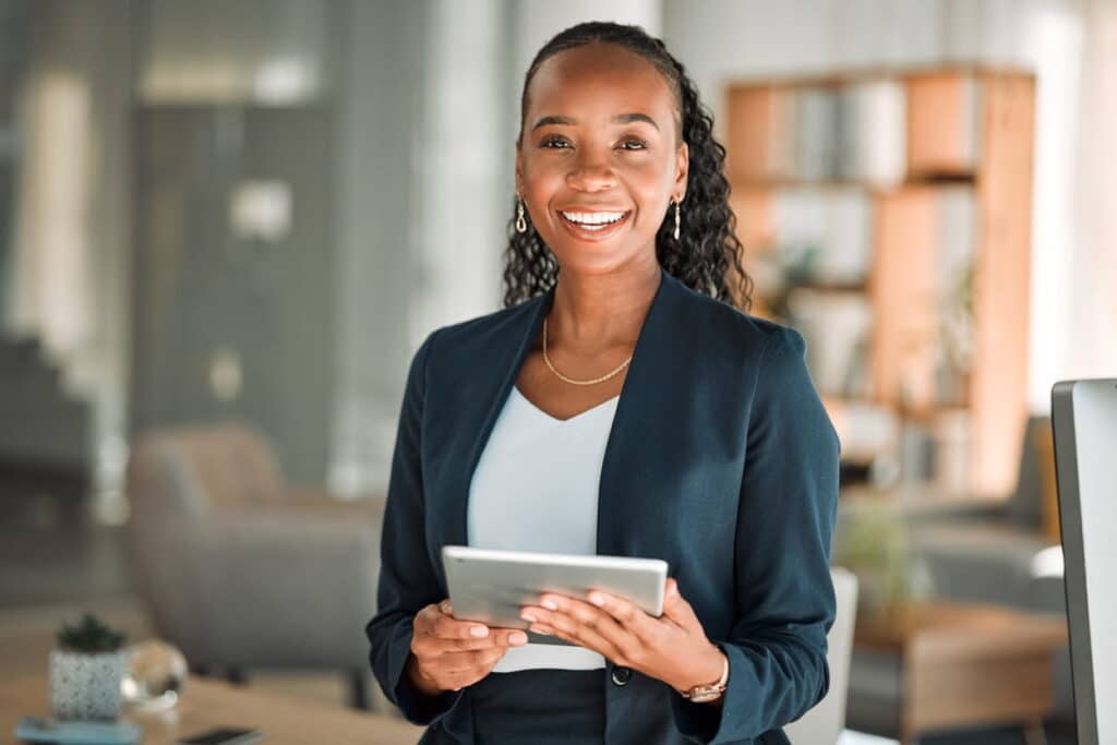 A truck accident attorney smiling while holding a tablet. 