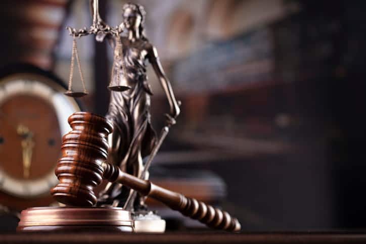 A gavel in front of a Lady Justice statue on a car accident attorney's desk. 