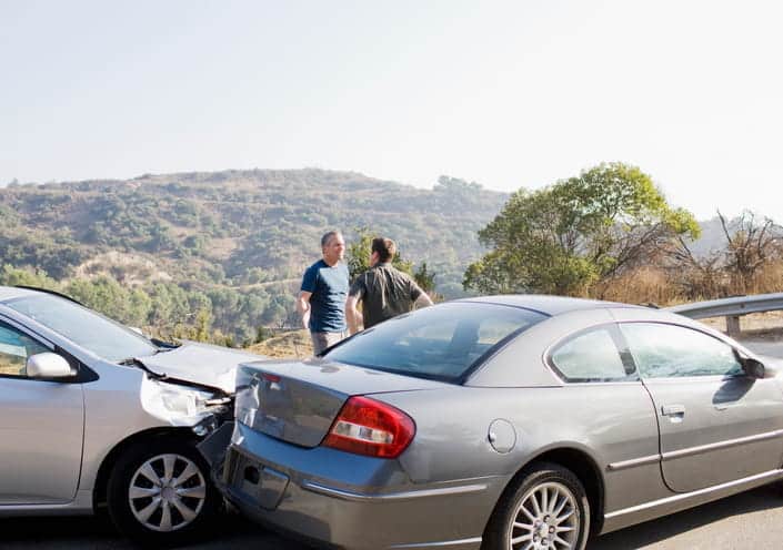 Rear-End Car Accident Lawyer In Las Vegas 1 Two men arguing outside of their damaged vehicles after being in a rear-end collision.