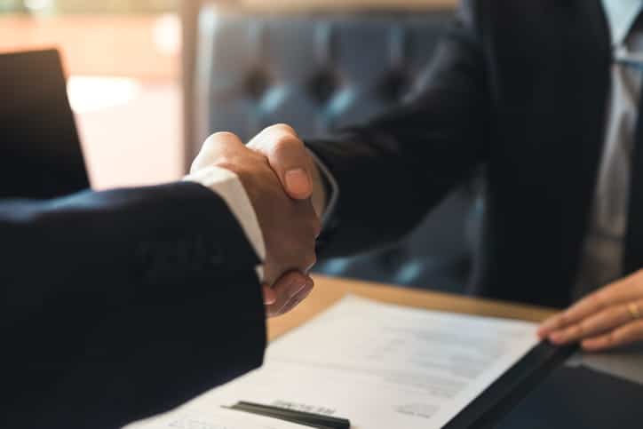 A premises liability lawyer shaking hands with their client. 