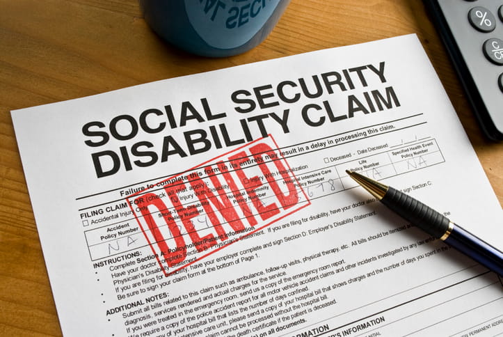 A social security disability claim form that has a red "denied" stamp on it.