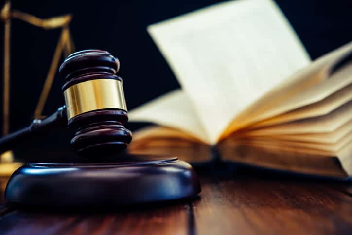 A gavel in front of an open book on a car accident injury attorney's desk. 