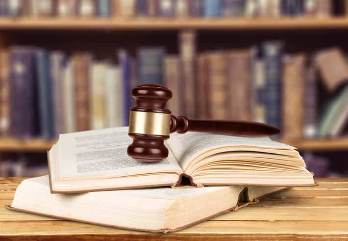 A gavel sitting on two open law books.