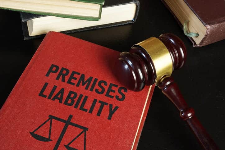 A law book that reads: "premises liability" next to other textbooks and a gavel.