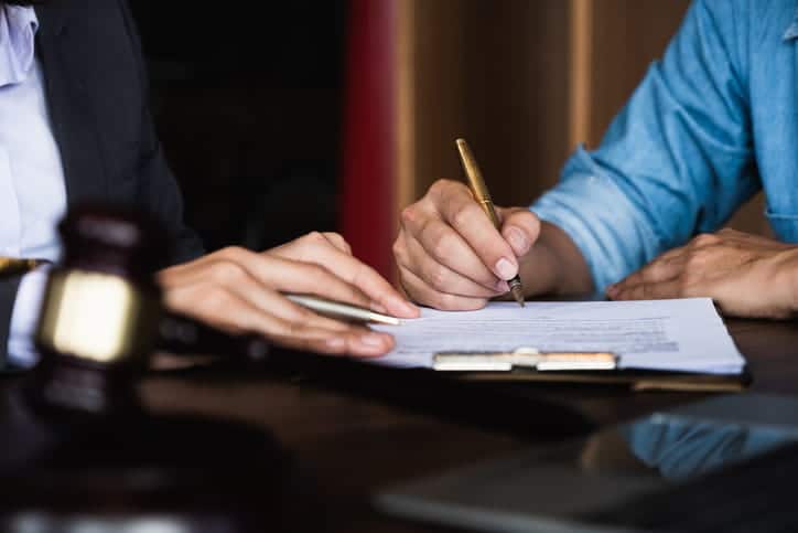 An attorney helping a client fill out paperwork. 