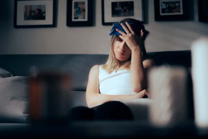 A woman holding an ice pack to her head after having a concussion. 