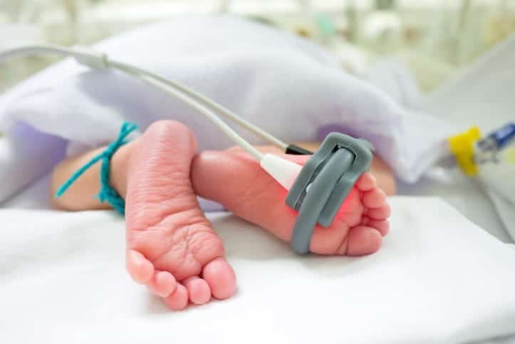 The focus is on a newborn's feet as they are in the nicu.